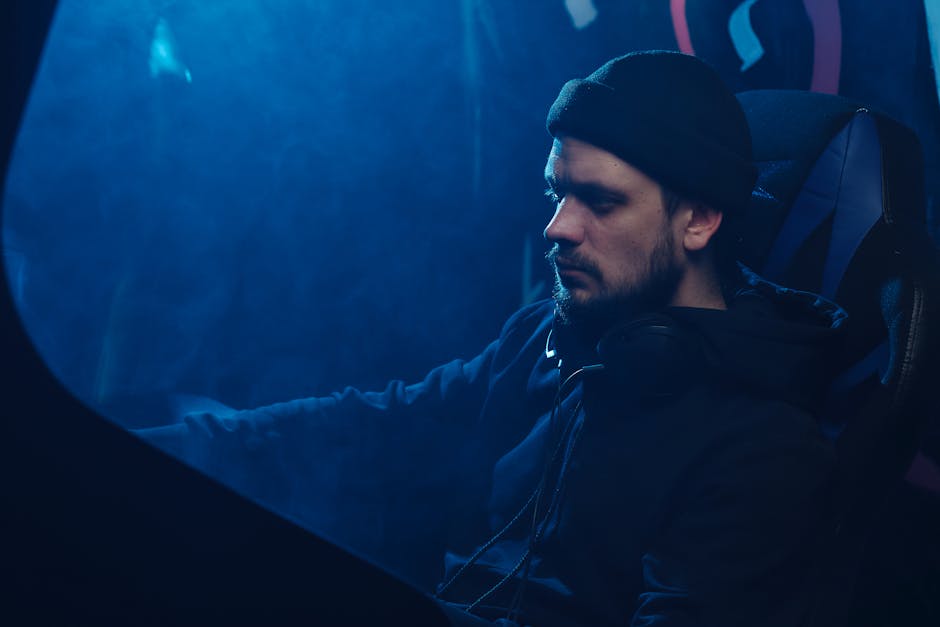 A contemplative scene featuring a man with headphones immersed in a moody blue ambiance.